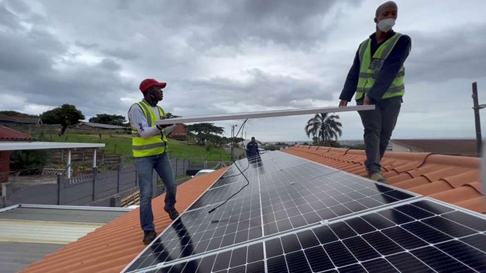 Workers installing rooftop solar PV demonstration units